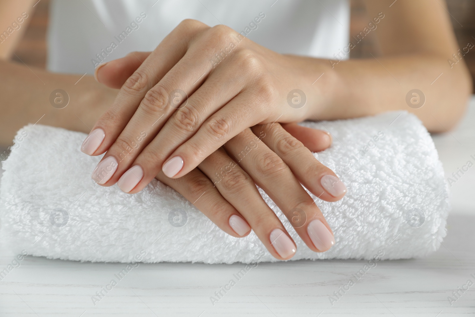 Photo of Woman showing smooth hands on towel, closeup. Spa treatment