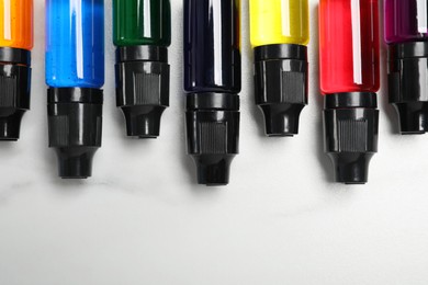 Photo of Bottles with different food coloring on white background, flat lay