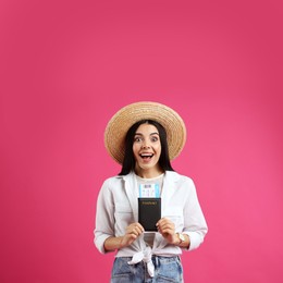 Emotional female tourist with ticket and passport on pink background