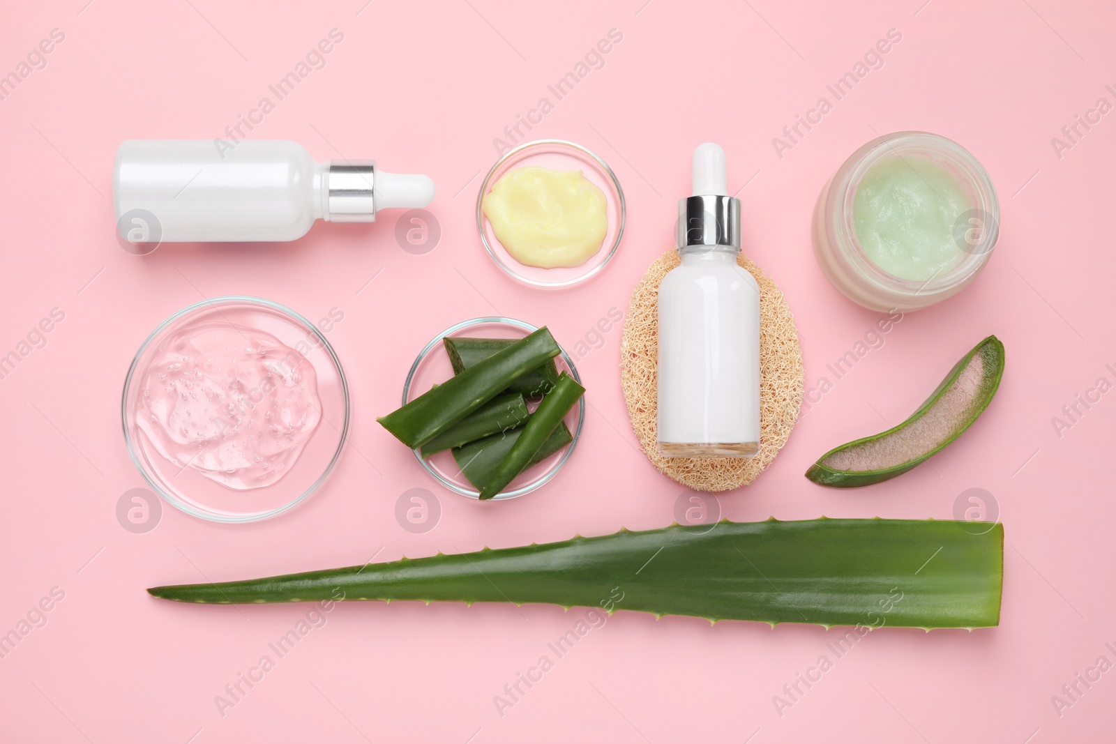 Photo of Flat lay composition with cosmetic products and cut aloe leaves on pink background