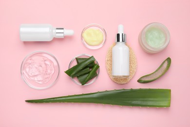 Flat lay composition with cosmetic products and cut aloe leaves on pink background