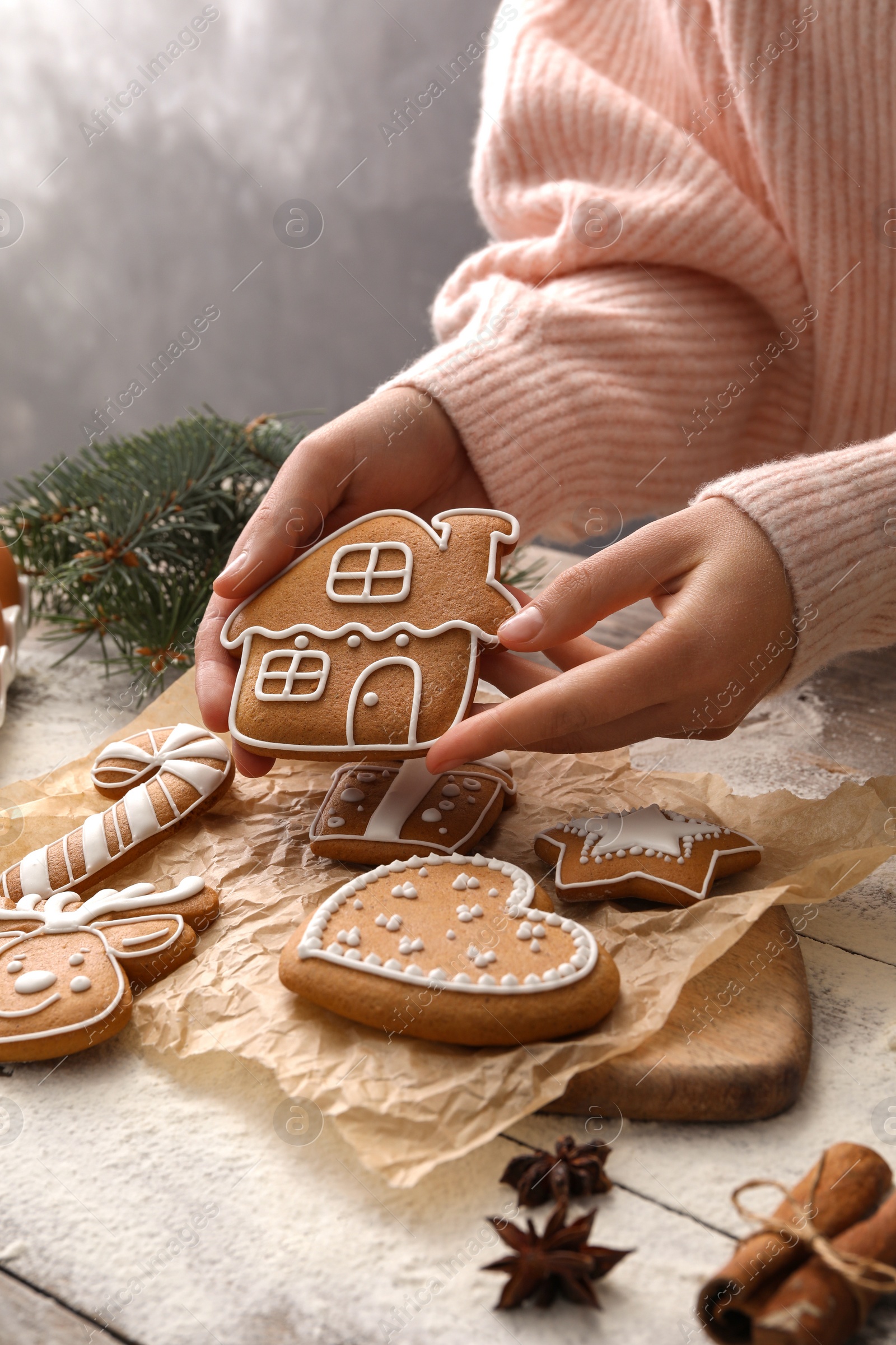 Photo of Woman holding delicious homemade Christmas cookie at wooden table, closeup