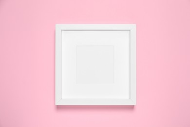 Photo of Empty photo frame on pink background, top view. Space for design