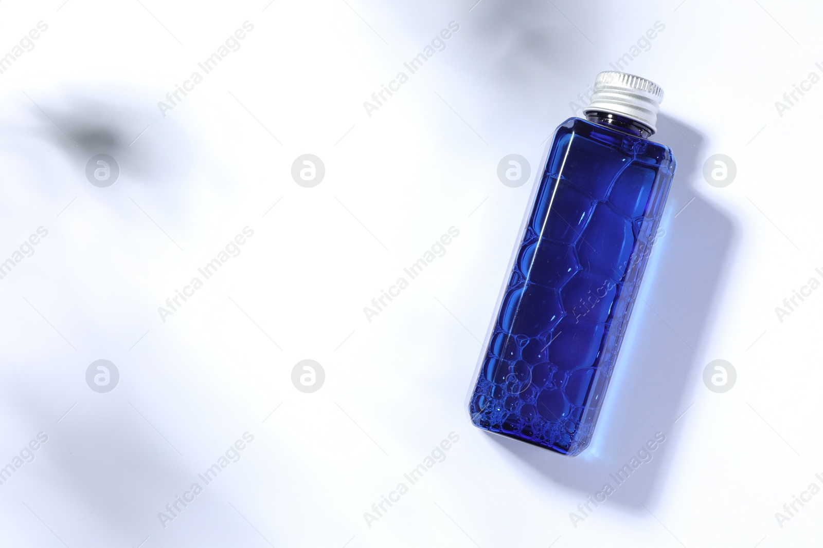 Photo of Bottle of cosmetic product on white background, top view. Space for text