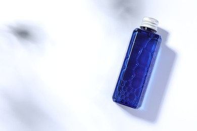 Bottle of cosmetic product on white background, top view. Space for text