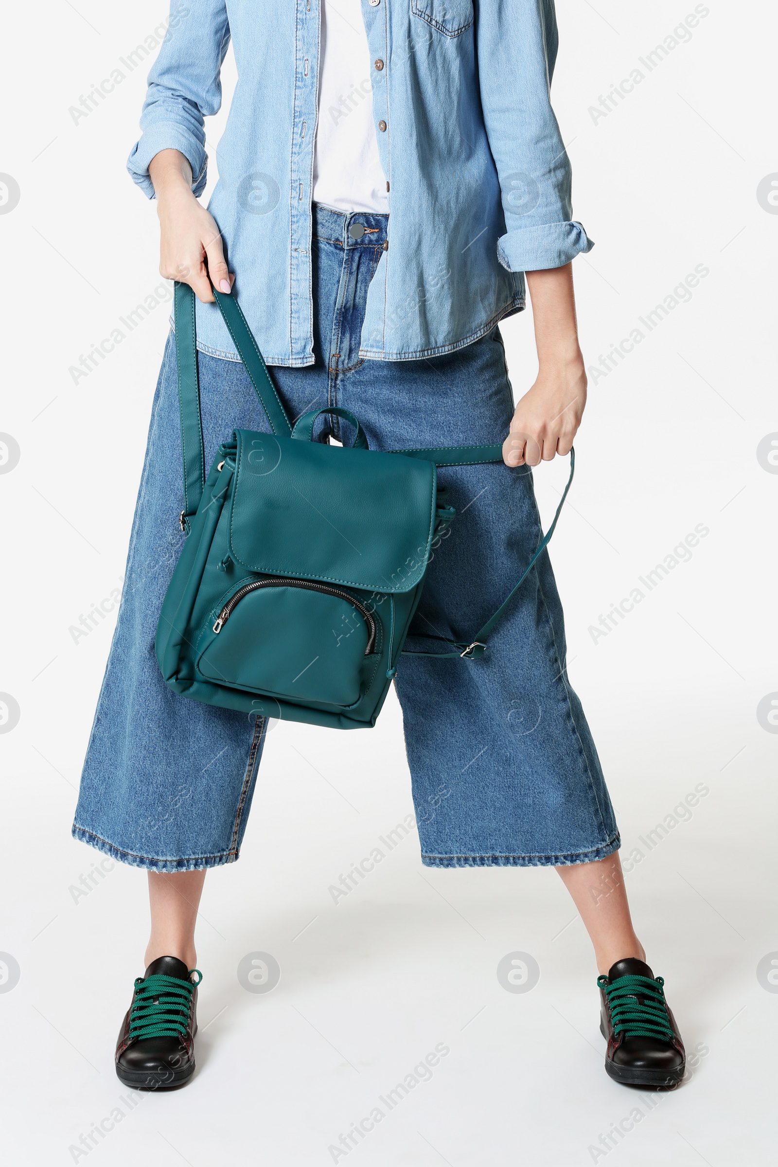 Photo of Fashionable woman in stylish shoes holding backpack isolated on white