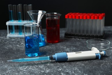 Laboratory analysis. Micropipette, beakers, flask, petri dish and test tubes on grey table