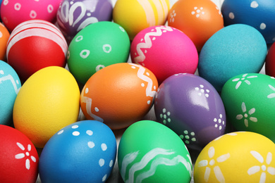 Photo of Many bright Easter eggs as background, closeup view
