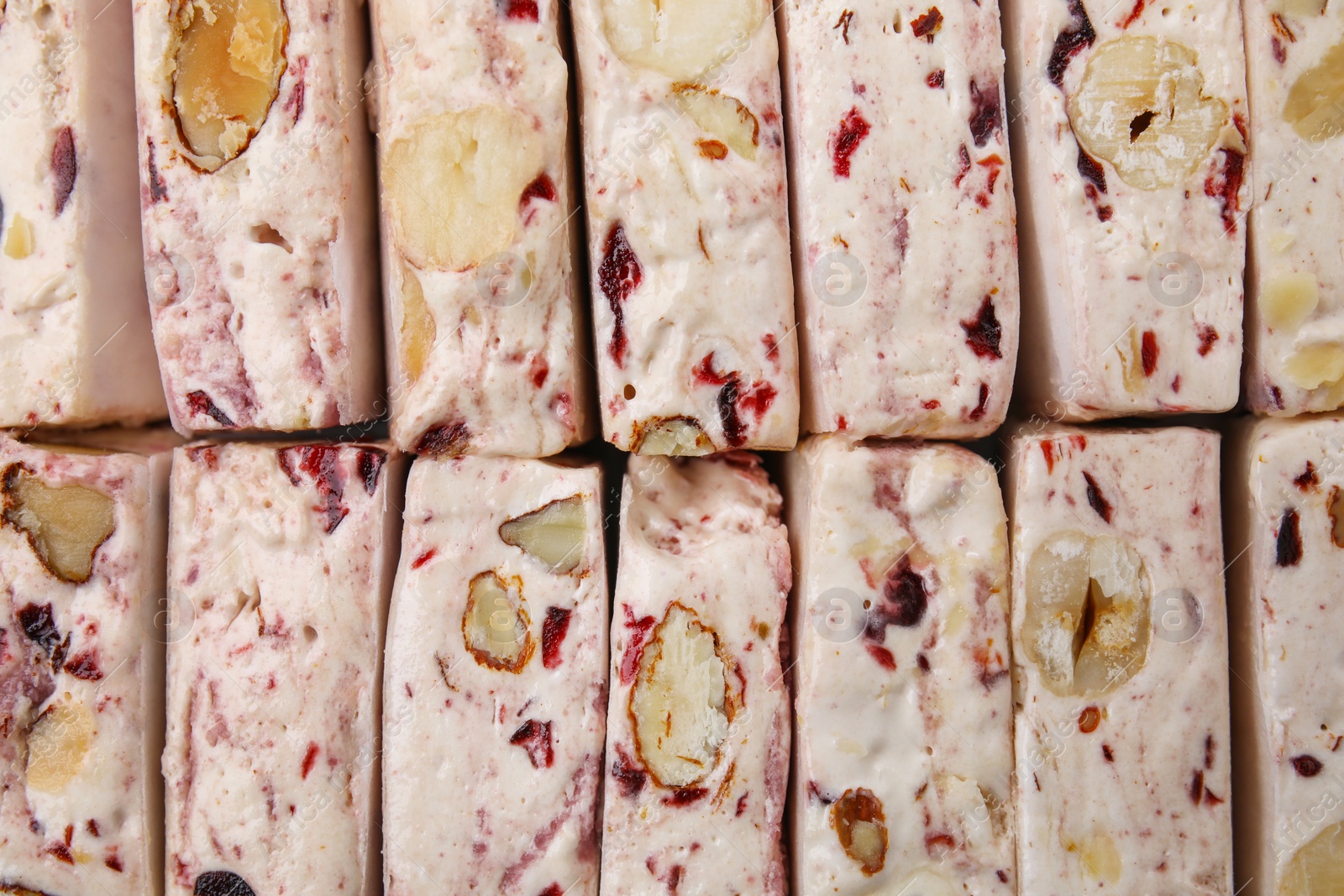 Photo of Pieces of delicious nougat as background, top view