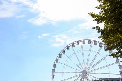 Picturesque view of beautiful Ferris wheel in city, space for text