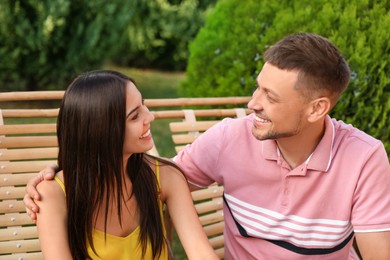 Image of Happy couple resting in deck chairs outdoors