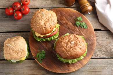 Photo of Delicious vegetarian burgers served on wooden table