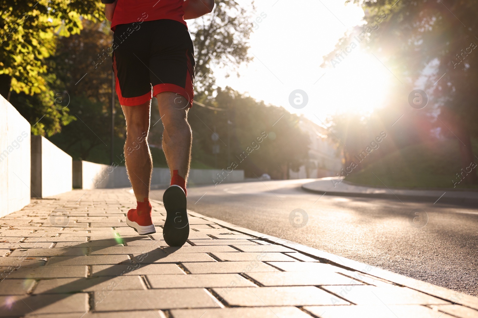 Photo of Man running outdoors on sunny day, closeup. Space for text
