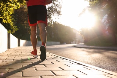 Photo of Man running outdoors on sunny day, closeup. Space for text