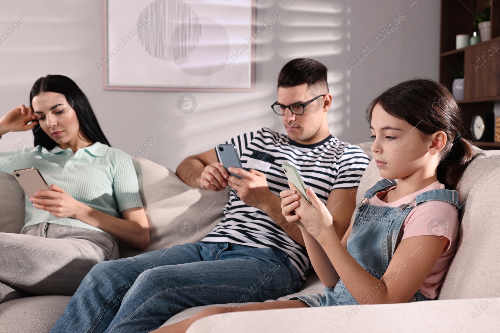 Photo of Internet addiction. Family with different gadgets on sofa at home