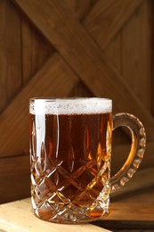 Photo of Mug with fresh beer on wooden crate