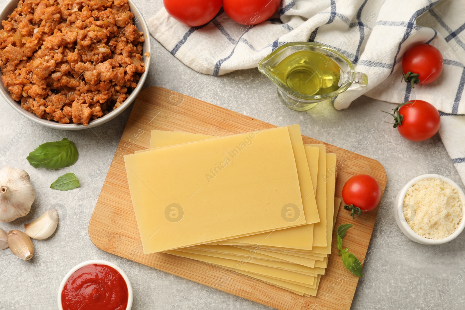 Photo of Flat lay composition with products for cooking lasagna on grey textured table