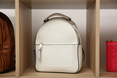 Photo of Stylish white woman's bag on wooden shelf