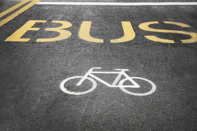 Bicycle and bus lane signs painted on asphalt