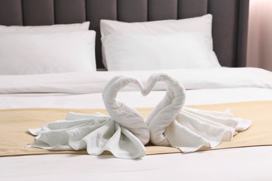 Photo of Honeymoon. Swans made of towels on bed in room