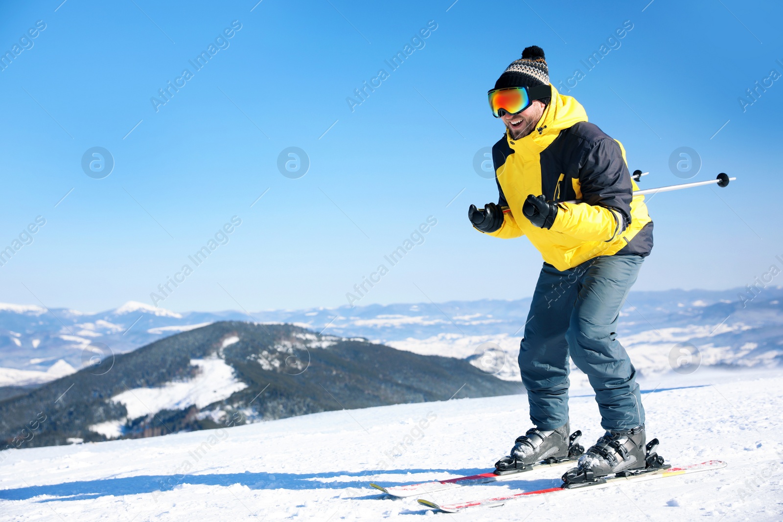 Photo of Young man skiing on hill, space for text. Winter vacation