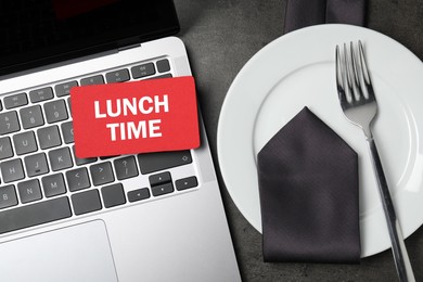 Business lunch time. Laptop, card, plate, fork and tie on gray table, flat lay