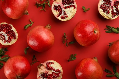 Flat lay composition with ripe pomegranates on red background