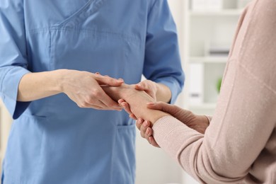 Photo of Arthritis symptoms. Doctor examining patient's wrist in hospital, closeup