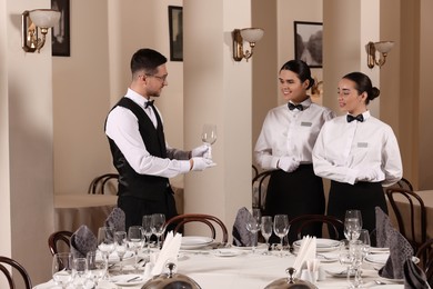 Photo of People setting table during professional butler courses in restaurant