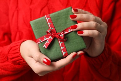 Christmas present. Woman holding gift box, closeup