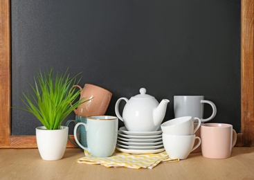 Photo of Set of dishware on table near chalkboard