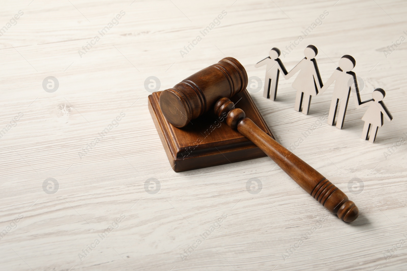 Photo of Law concept. Gavel and figures of parents with children on white wooden table, space for text