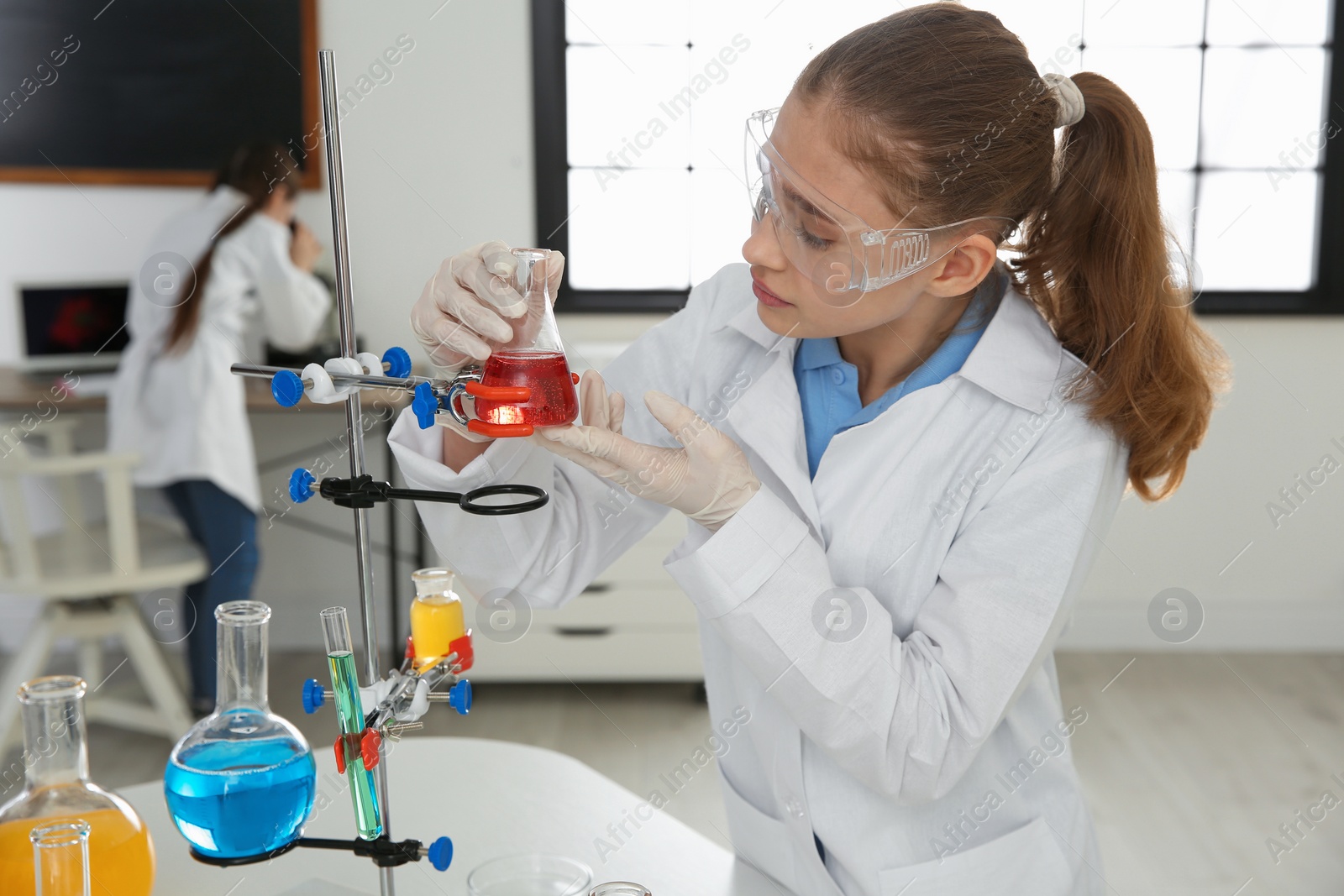 Photo of Smart pupil making experiment in chemistry class