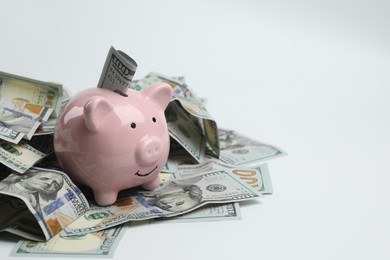 Money exchange. Dollar banknotes and piggy bank on white background, closeup. Space for text