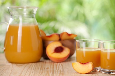 Photo of Tasty peach juice and fresh fruits on wooden table outdoors, closeup. Space for text