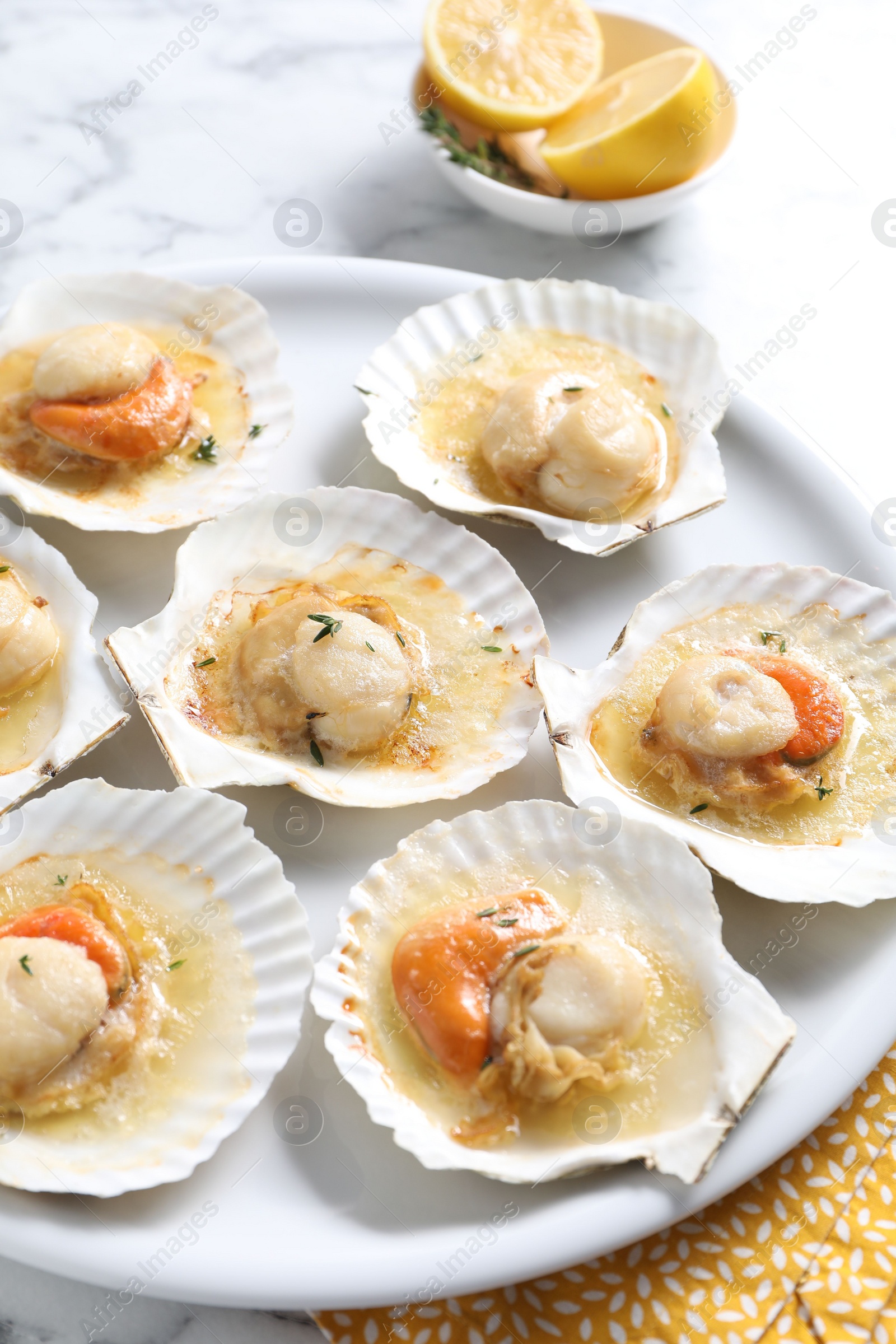 Photo of Fried scallops in shells on white marble table