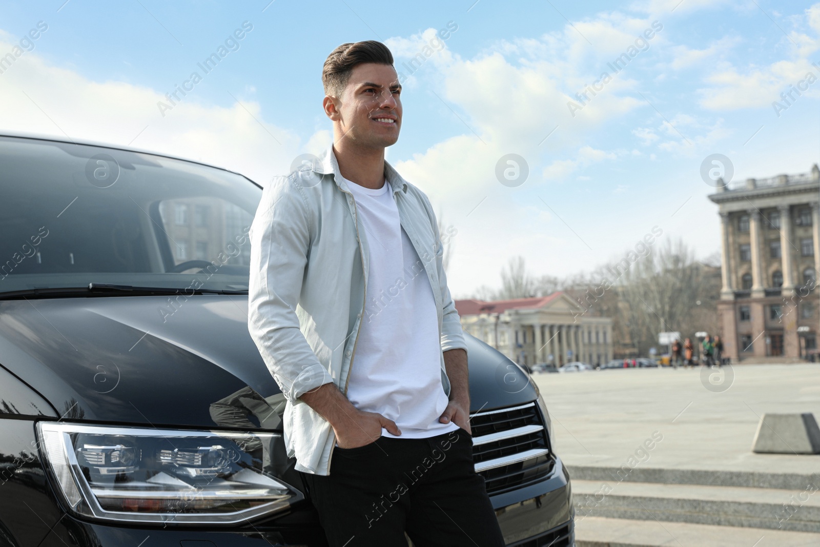 Photo of Handsome man near modern car on city street