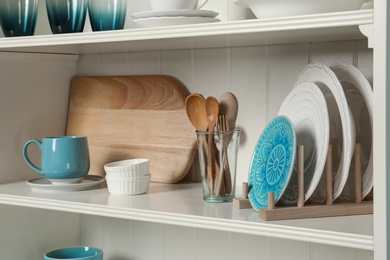 Photo of White shelving unit with set of dishware