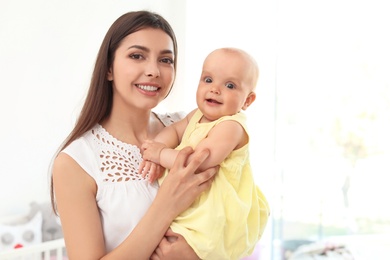 Photo of Young mother with her cute baby girl at home