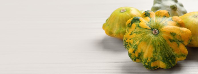 Image of Fresh pattypan squashes on white wooden table, closeup and space for text. Banner design