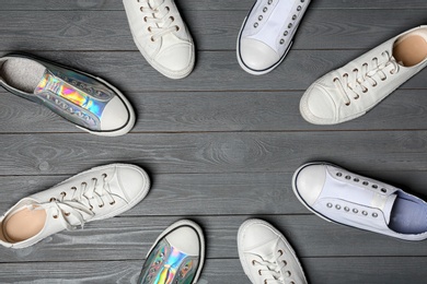 Photo of Flat lay composition with sneakers and space for text on wooden background. Stylish shoes