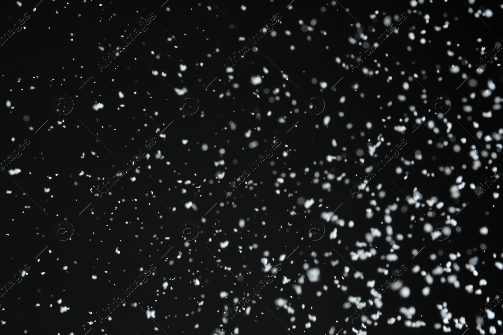 Photo of White snow falling down on black background