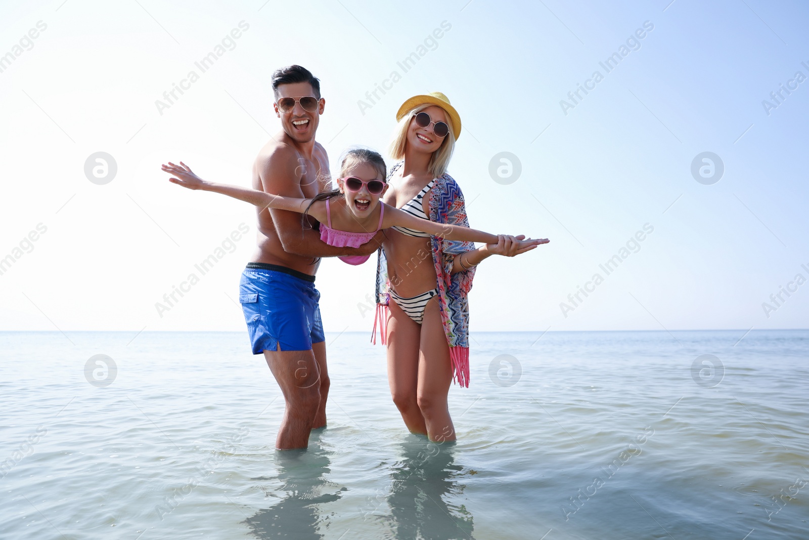 Photo of Parents playing with daughter at beach. Family vacation