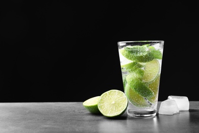 Photo of Refreshing beverage with mint and lime in glass on table