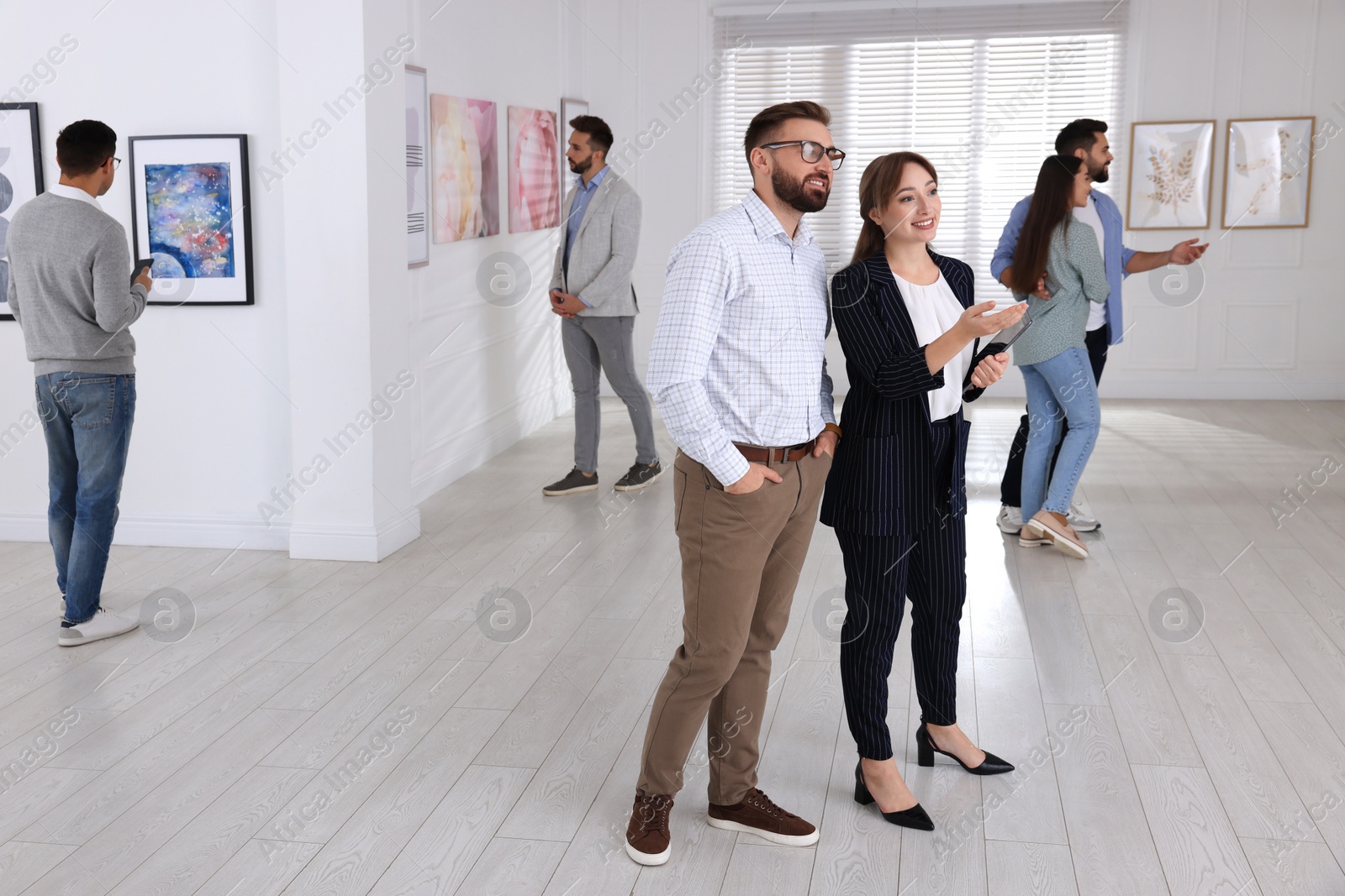 Photo of People viewing exposition in modern art gallery