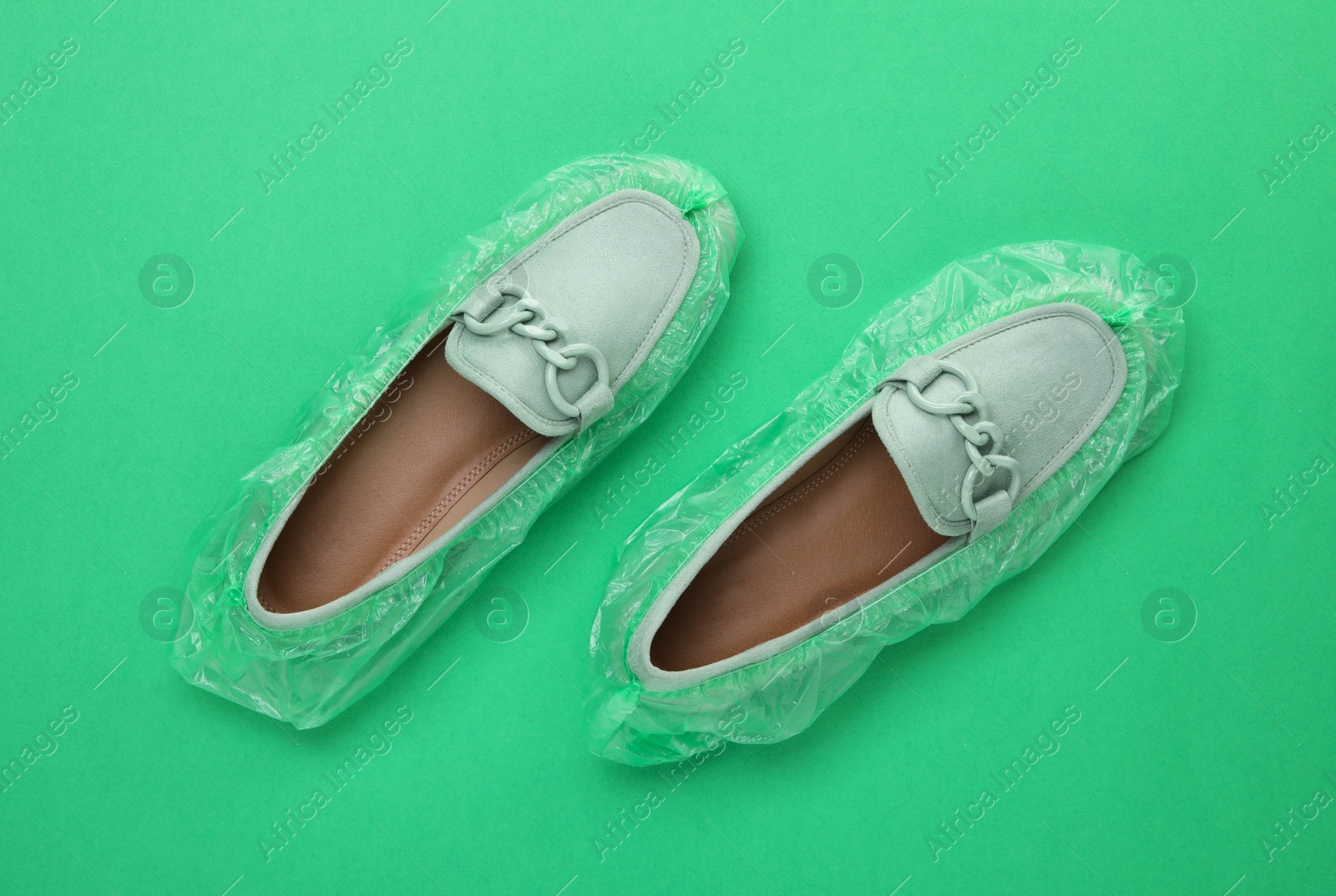 Photo of Women's mules in shoe covers on green background, top view