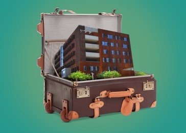 Image of Building in retro suitcase on green background