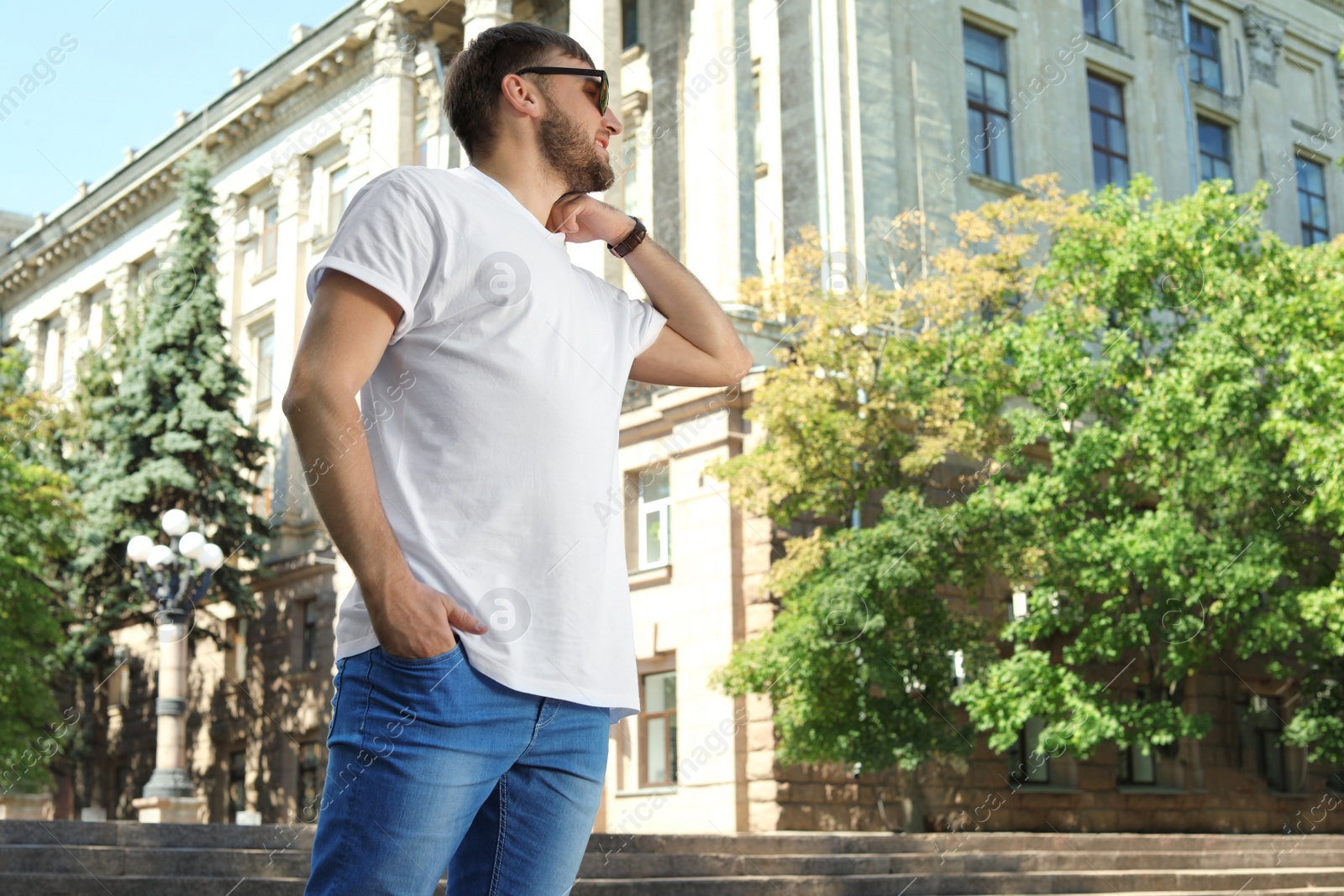 Photo of Young man wearing white t-shirt on street