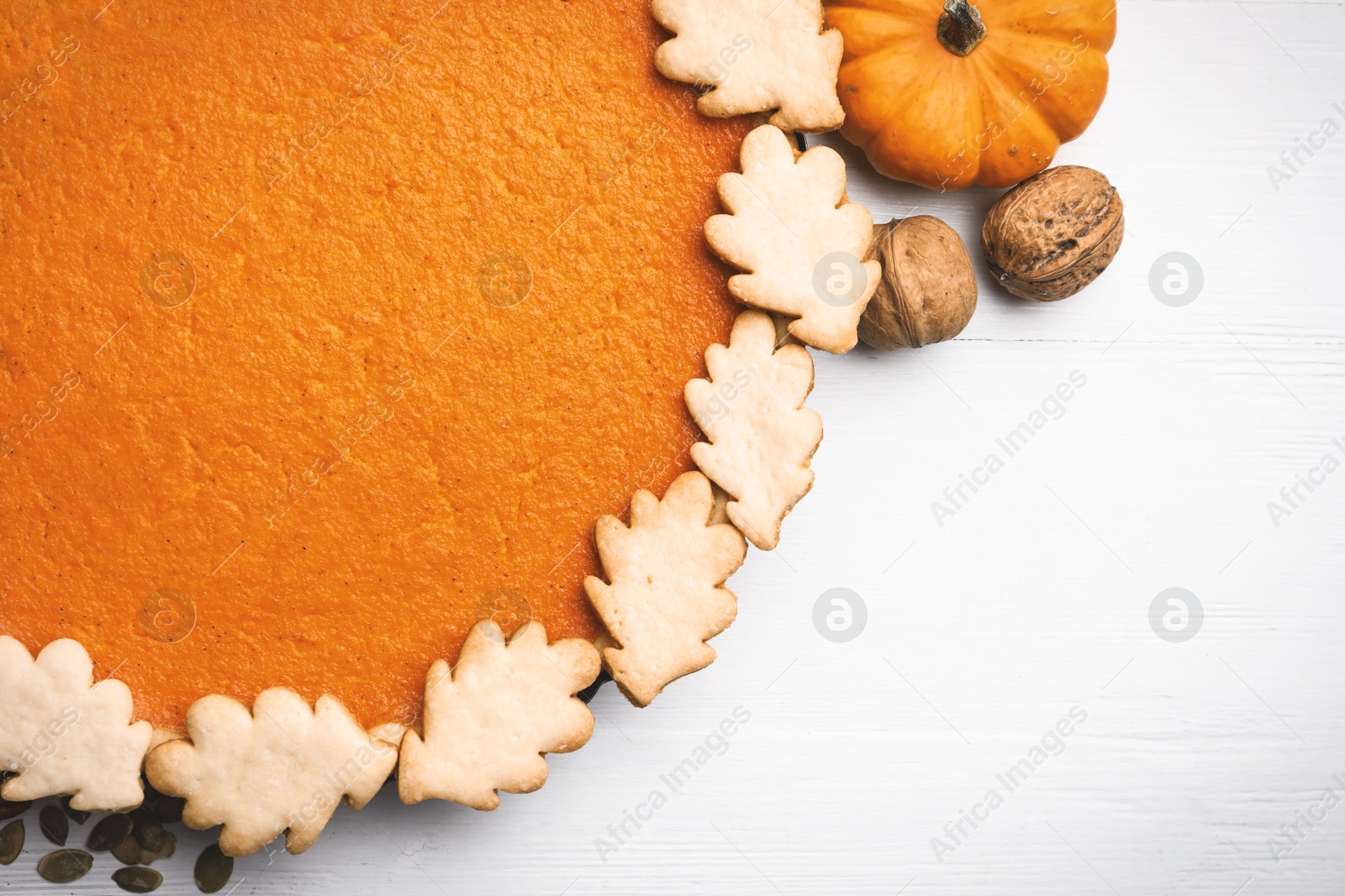 Photo of Delicious homemade pumpkin pie on white wooden table, flat lay. Space for text