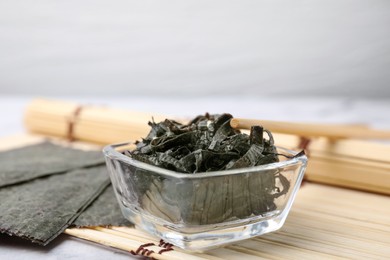 Chopped nori sheets with chopsticks on table, closeup